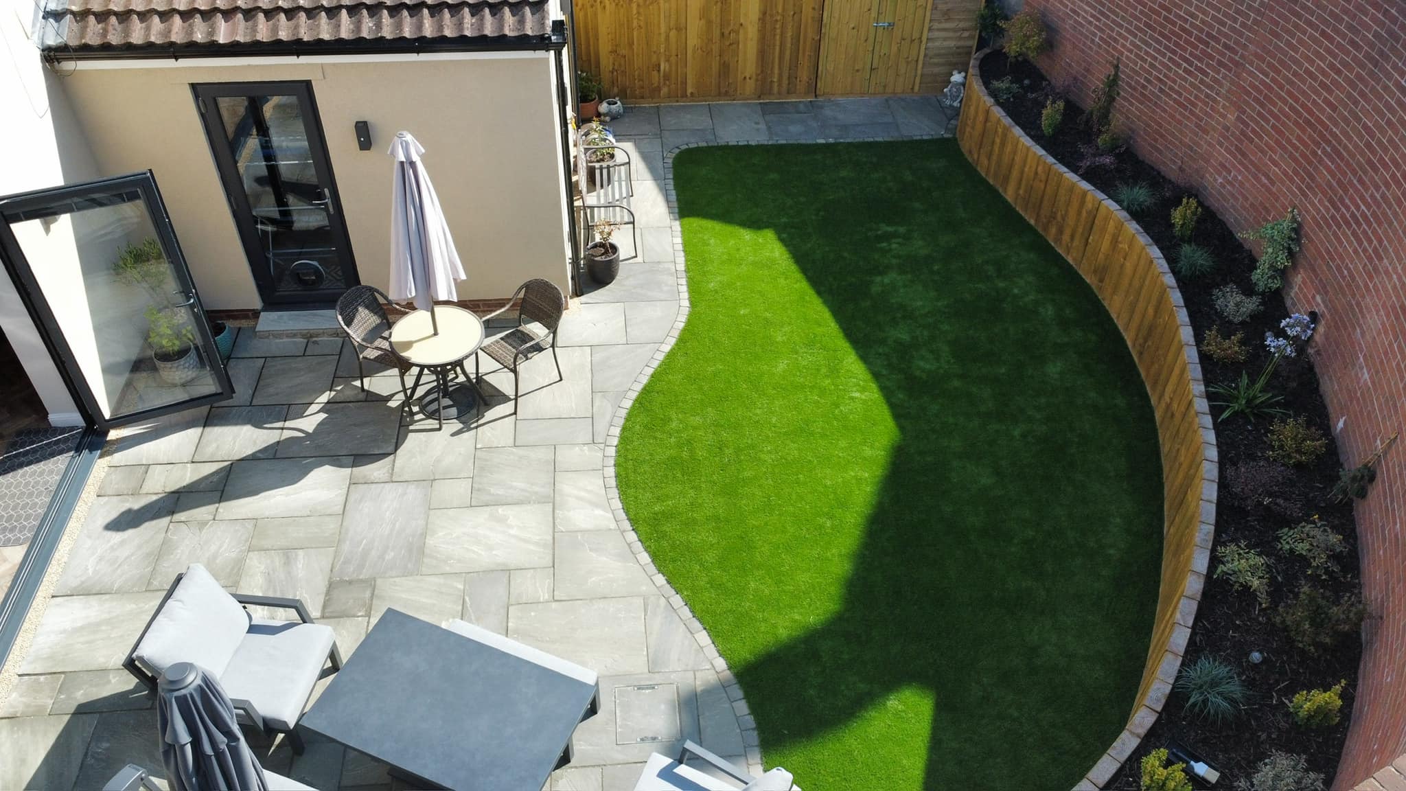 Aerial view of patio and curved artificial grass garden