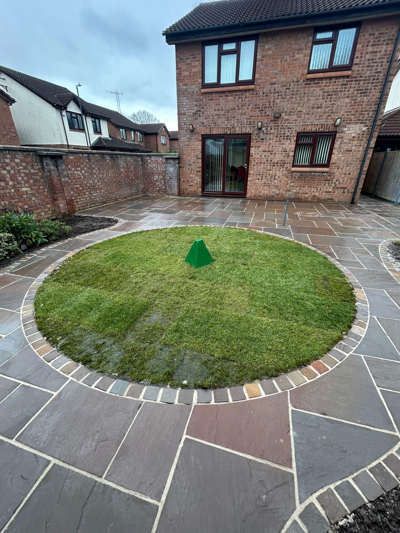 Circular lawn feature with Indian sandstone patio